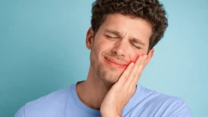 Un homme souffre d'une douleur dentaire et consulte un dentiste à Lausanne en urgence